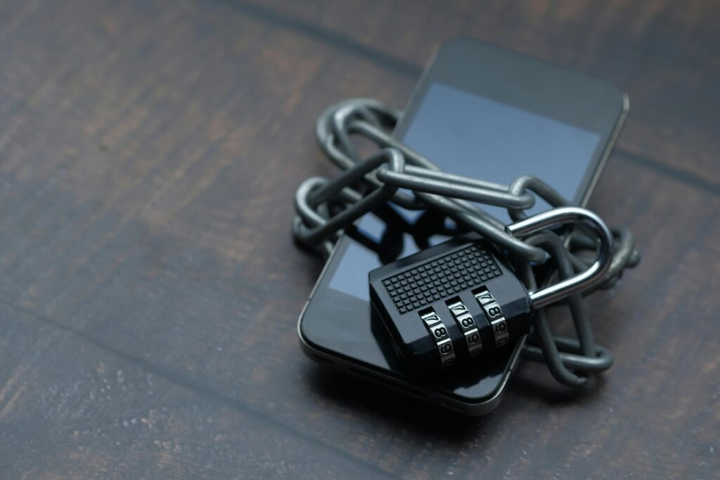 What Is a Crypto Wallet and Do You Really Need One? Close-up of a smartphone wrapped in a chain with a padlock, symbolizing strong security.