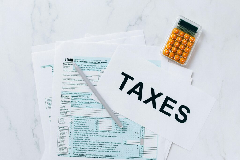 Crypto Taxes Explained: What You Need to Know Top view of tax forms, a calculator, and pen for tax preparation.
