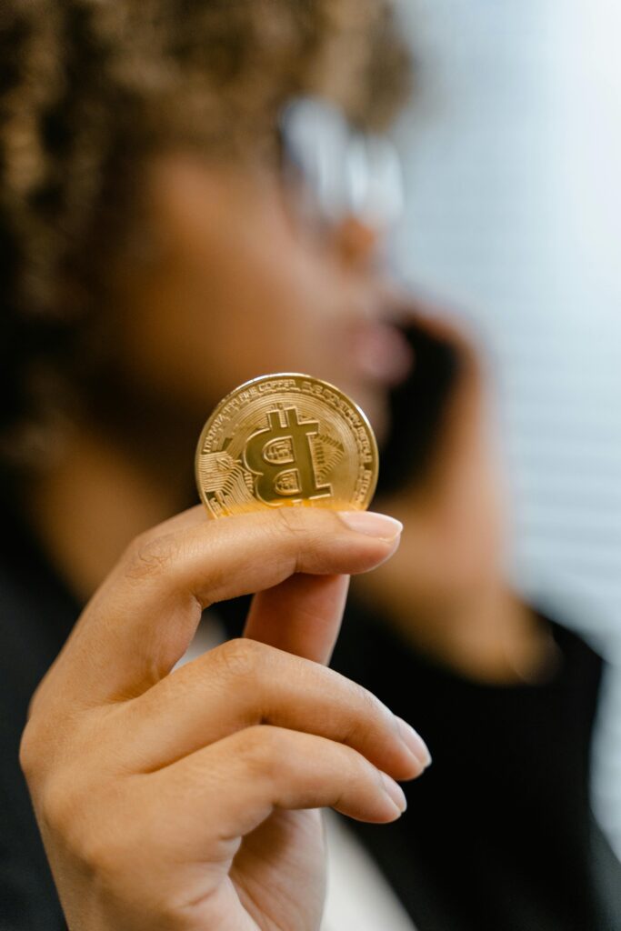 A person holding a Bitcoin coin, symbolizing digital currency and investment.