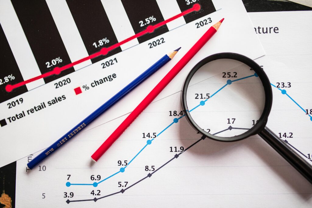 How to Read a Crypto Chart as a Complete Beginner Magnifying glass and colored pencils on financial trend graphs highlighting sales growth.