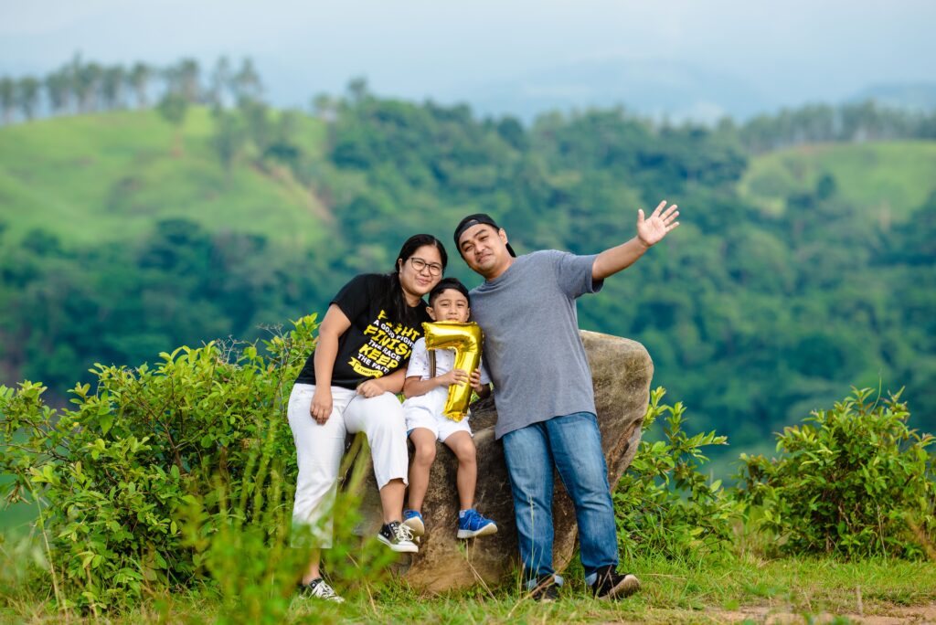 A joyful family celebrating with a balloon in a lush, green outdoor setting.